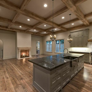 Large mediterranean open concept kitchen appliance - Inspiration for a large mediterranean u-shaped medium tone wood floor open concept kitchen remodel in Houston with a farmhouse sink, gray cabinets, soapstone countertops, beige backsplash, subway tile backsplash, stainless steel appliances and an island