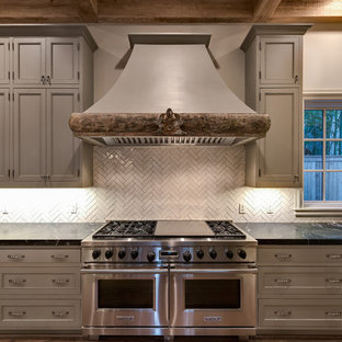 Large mediterranean open concept kitchen photos - Example of a large tuscan u-shaped medium tone wood floor open concept kitchen design in Houston with an undermount sink, beaded inset cabinets, gray cabinets, soapstone countertops, beige backsplash, ceramic backsplash, stainless steel appliances and an island