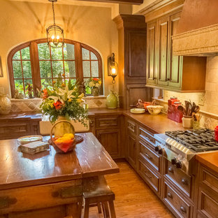 Kleine Mediterrane Wohnküche in L-Form mit Landhausspüle, Schrankfronten im Shaker-Stil, hellbraunen Holzschränken, Betonarbeitsplatte, Küchenrückwand in Beige, Rückwand aus Steinfliesen, Küchengeräten aus Edelstahl, braunem Holzboden und Kücheninsel in St. Louis