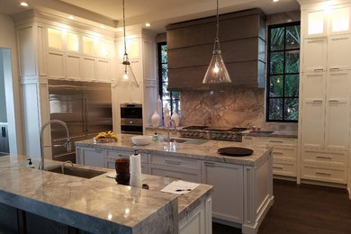 Inspiration for a large contemporary medium tone wood floor and brown floor kitchen remodel in Tampa with an undermount sink, recessed-panel cabinets, white cabinets, quartzite countertops, gray backsplash, stone slab backsplash, stainless steel appliances and two islands