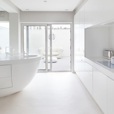 Trendy kitchen photo in London with flat-panel cabinets, white cabinets, white backsplash and an island