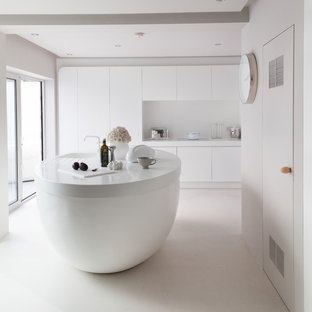 Imagen de cocina actual con armarios con paneles lisos, puertas de armario blancas, salpicadero blanco y una isla
