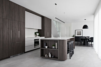 Foto di una cucina minimal con lavello sottopiano, ante lisce, ante grigie, elettrodomestici in acciaio inossidabile, pavimento grigio e top bianco