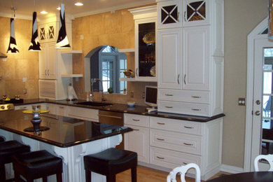 Foto de cocina comedor clásica renovada con armarios con paneles con relieve, puertas de armario blancas, encimera de madera y una isla