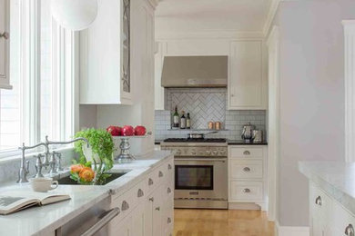 Inspiration for a mid-sized transitional light wood floor eat-in kitchen remodel in Boston with an undermount sink, shaker cabinets, white cabinets, marble countertops, subway tile backsplash, stainless steel appliances, an island and white backsplash