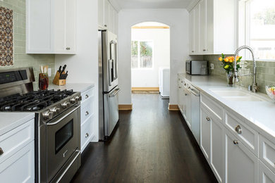 Elegant galley dark wood floor kitchen pantry photo in Los Angeles with a drop-in sink, shaker cabinets, white cabinets, quartz countertops, ceramic backsplash, stainless steel appliances and no island
