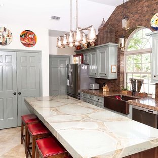 Design ideas for a large transitional u-shaped kitchen pantry in Houston with a farmhouse sink, beaded inset cabinets, green cabinets, quartzite benchtops, brown splashback, metal splashback, stainless steel appliances, porcelain floors, with island, beige floor and green benchtop.