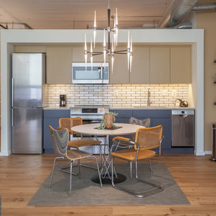Small industrial eat-in kitchen photos - Inspiration for a small industrial single-wall medium tone wood floor and brown floor eat-in kitchen remodel in Philadelphia with an undermount sink, flat-panel cabinets, quartz countertops, white backsplash, subway tile backsplash, stainless steel appliances, no island and blue cabinets