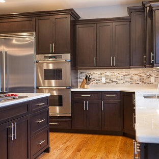 Large transitional eat-in kitchen appliance - Inspiration for a large transitional l-shaped light wood floor eat-in kitchen remodel in New York with shaker cabinets, dark wood cabinets, granite countertops, gray backsplash, matchstick tile backsplash, stainless steel appliances, an undermount sink and an island