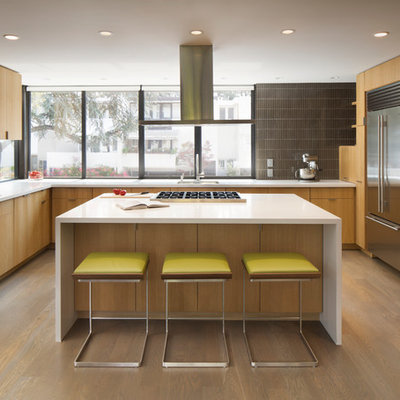 Inspiration for a mid-century modern light wood floor kitchen remodel in San Francisco with an undermount sink, flat-panel cabinets, light wood cabinets, quartz countertops, glass tile backsplash, stainless steel appliances, an island and brown backsplash
