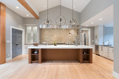 This is an example of an expansive contemporary single-wall open plan kitchen in San Francisco with a submerged sink, shaker cabinets, white cabinets, granite worktops, beige splashback, stone tiled splashback, stainless steel appliances, light hardwood flooring and an island.