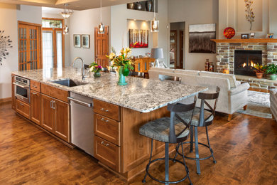 Inspiration for a mid-sized contemporary medium tone wood floor and brown floor eat-in kitchen remodel in Milwaukee with medium tone wood cabinets, granite countertops, multicolored backsplash, stainless steel appliances, an island and multicolored countertops