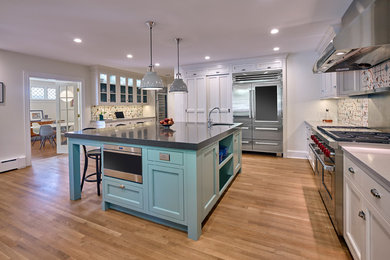 Example of a huge transitional u-shaped light wood floor kitchen pantry design in New York with a farmhouse sink, recessed-panel cabinets, white cabinets, granite countertops, multicolored backsplash, porcelain backsplash, stainless steel appliances, an island and gray countertops