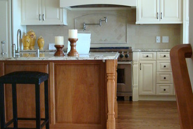 Idéer för att renovera ett stort vintage kök, med en rustik diskho, luckor med upphöjd panel, vita skåp, granitbänkskiva, beige stänkskydd, stänkskydd i stenkakel, rostfria vitvaror, mellanmörkt trägolv och en köksö