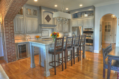 Open concept kitchen - l-shaped open concept kitchen idea in Louisville with an island
