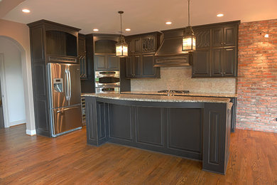 L-shaped open concept kitchen photo in Louisville with recessed-panel cabinets and an island