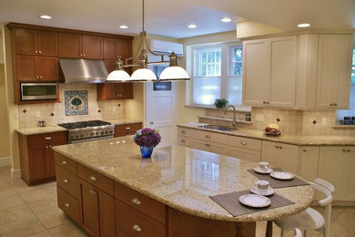Inspiration for a large transitional u-shaped ceramic tile and beige floor enclosed kitchen remodel in Philadelphia with an undermount sink, recessed-panel cabinets, granite countertops, beige backsplash, ceramic backsplash, stainless steel appliances, an island and medium tone wood cabinets