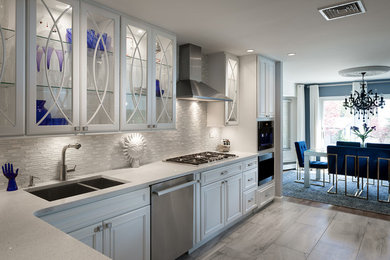 Inspiration for a mid-sized contemporary l-shaped porcelain tile and gray floor enclosed kitchen remodel in New York with an undermount sink, recessed-panel cabinets, white cabinets, quartz countertops, white backsplash, glass tile backsplash, stainless steel appliances and white countertops