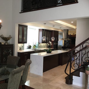 Foto di una cucina chic di medie dimensioni con lavello stile country, ante di vetro, ante in legno bruno, top in marmo, paraspruzzi grigio, paraspruzzi con piastrelle di vetro, elettrodomestici da incasso e pavimento in travertino