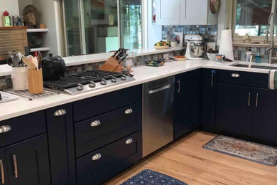 Mid-sized eclectic l-shaped light wood floor and beige floor eat-in kitchen photo in Denver with a single-bowl sink, shaker cabinets, blue cabinets, quartz countertops, multicolored backsplash, glass sheet backsplash, stainless steel appliances, a peninsula and white countertops