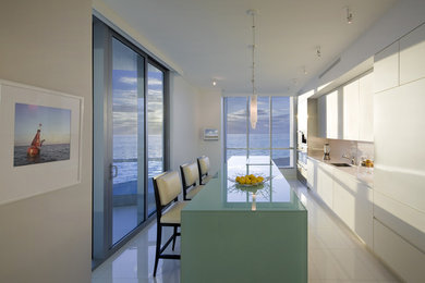 На фото: кухня в стиле модернизм с техникой под мебельный фасад и белым полом