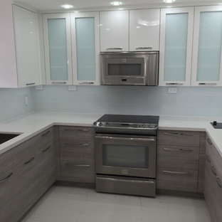 Photo of a mid-sized contemporary u-shaped separate kitchen in Miami with an undermount sink, flat-panel cabinets, grey cabinets, recycled glass benchtops, white splashback, glass tile splashback, stainless steel appliances, marble floors and no island.