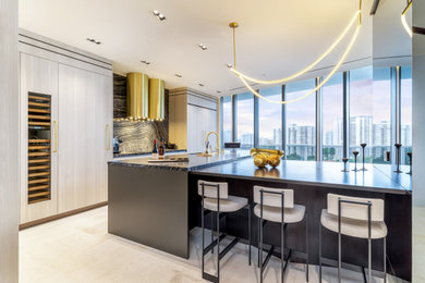 Eat-in kitchen - large contemporary l-shaped porcelain tile and beige floor eat-in kitchen idea in Miami with an undermount sink, flat-panel cabinets, light wood cabinets, marble countertops, black backsplash, marble backsplash, paneled appliances, a peninsula and black countertops