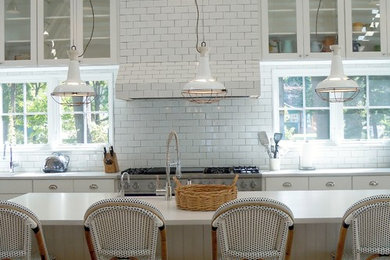 Foto på ett lantligt kök, med en rustik diskho, vita skåp, bänkskiva i kvarts, vitt stänkskydd, stänkskydd i tunnelbanekakel och ljust trägolv