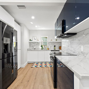 Small contemporary kitchen designs - Inspiration for a small contemporary l-shaped vinyl floor and brown floor kitchen remodel in Tampa with an undermount sink, flat-panel cabinets, blue cabinets, granite countertops, white backsplash, granite backsplash, no island, white countertops and black appliances