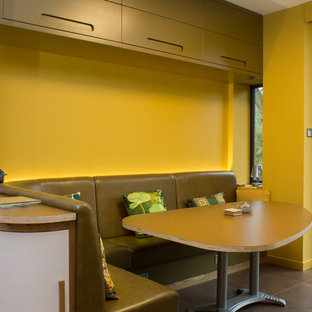 Large midcentury l-shaped eat-in kitchen in Manchester with an integrated sink, flat-panel cabinets, yellow cabinets, quartz benchtops, stainless steel appliances, porcelain floors, with island and brown floor.