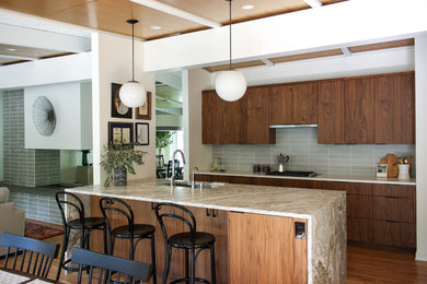 Exempel på ett retro grå grått kök, med släta luckor, skåp i mellenmörkt trä, bänkskiva i kvartsit, grått stänkskydd, stänkskydd i glaskakel, mellanmörkt trägolv, en köksö, brunt golv och en undermonterad diskho