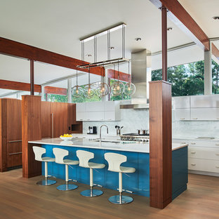 Idee per una cucina minimalista di medie dimensioni con ante lisce, ante bianche, top in marmo, paraspruzzi in marmo, parquet chiaro, isola, lavello a doppia vasca, paraspruzzi bianco, elettrodomestici in acciaio inossidabile e pavimento marrone