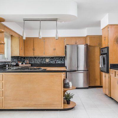 Inspiration for a mid-century modern u-shaped gray floor kitchen remodel in Indianapolis with a drop-in sink, flat-panel cabinets, medium tone wood cabinets, multicolored backsplash, mosaic tile backsplash, stainless steel appliances, a peninsula and black countertops