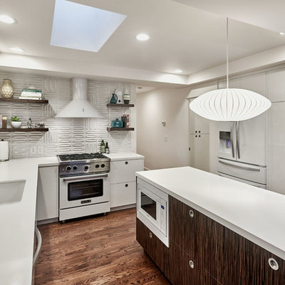 Mid-sized 1960s u-shaped dark wood floor and brown floor open concept kitchen photo in San Francisco with an undermount sink, flat-panel cabinets, white cabinets, white backsplash, white appliances, an island and quartzite countertops