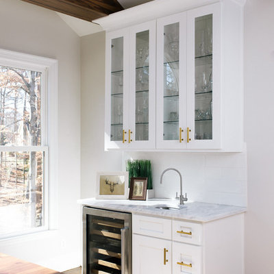 Eat-in kitchen - large transitional l-shaped dark wood floor eat-in kitchen idea in Atlanta with a farmhouse sink, shaker cabinets, white cabinets, marble countertops, white backsplash, ceramic backsplash, stainless steel appliances and an island