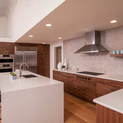 Example of a large 1960s u-shaped medium tone wood floor and brown floor open concept kitchen design in Seattle with an integrated sink, flat-panel cabinets, dark wood cabinets, quartzite countertops, gray backsplash, porcelain backsplash, stainless steel appliances, an island and white countertops