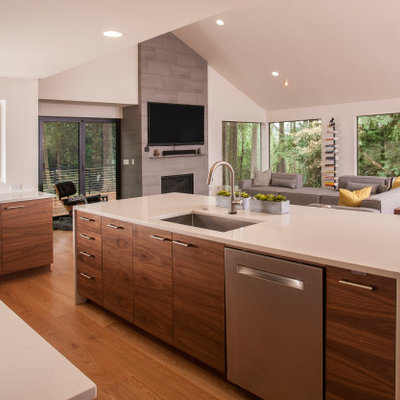 Example of a large mid-century modern u-shaped medium tone wood floor and brown floor open concept kitchen design in Seattle with an integrated sink, flat-panel cabinets, dark wood cabinets, quartzite countertops, gray backsplash, porcelain backsplash, stainless steel appliances, an island and white countertops