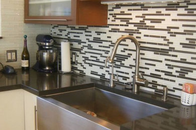 Example of a mid-sized 1960s medium tone wood floor kitchen pantry design in Los Angeles with white cabinets, quartz countertops, multicolored backsplash, stainless steel appliances, an island, a farmhouse sink, flat-panel cabinets and ceramic backsplash