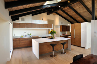 Example of a mid-sized mid-century modern light wood floor and brown floor open concept kitchen design in Vancouver with an undermount sink, flat-panel cabinets, medium tone wood cabinets, quartz countertops, an island, paneled appliances and white countertops