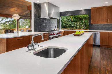 Large mid-century modern u-shaped medium tone wood floor open concept kitchen photo in Seattle with an undermount sink, flat-panel cabinets, light wood cabinets, quartz countertops, black backsplash, cement tile backsplash, stainless steel appliances and an island