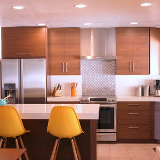 Inspiration pour une cuisine américaine vintage en U de taille moyenne avec un placard à porte plane, un plan de travail en quartz modifié, un électroménager en acier inoxydable, un îlot central, des portes de placard en bois brun, une crédence blanche, un évier encastré, une crédence en carrelage métro et un sol en carrelage de céramique.