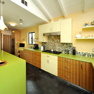 Contemporary galley kitchen/diner in Los Angeles with mosaic tiled splashback, flat-panel cabinets, medium wood cabinets, multi-coloured splashback, engineered stone countertops, a submerged sink, stainless steel appliances, concrete flooring, a breakfast bar and green worktops.