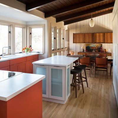 Inspiration for a mid-sized 1950s l-shaped light wood floor eat-in kitchen remodel in Atlanta with shaker cabinets, orange cabinets, solid surface countertops, an island, a double-bowl sink and stainless steel appliances
