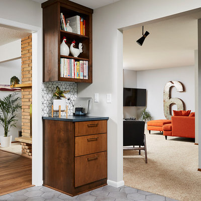 Example of a mid-sized 1960s u-shaped cement tile floor and gray floor enclosed kitchen design in Minneapolis with an undermount sink, flat-panel cabinets, medium tone wood cabinets, quartz countertops, white backsplash, cement tile backsplash, stainless steel appliances, no island and black countertops
