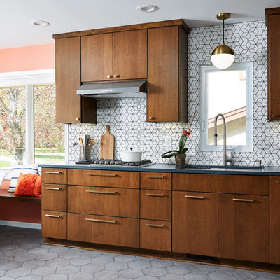Example of a mid-sized 1950s l-shaped cement tile floor and gray floor eat-in kitchen design in Minneapolis with an undermount sink, flat-panel cabinets, quartz countertops, white backsplash, cement tile backsplash, stainless steel appliances, no island, black countertops and dark wood cabinets