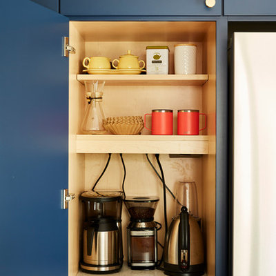Mid-sized 1960s u-shaped cement tile floor and gray floor enclosed kitchen photo in Minneapolis with an undermount sink, flat-panel cabinets, blue cabinets, quartz countertops, white backsplash, cement tile backsplash, stainless steel appliances, no island and black countertops