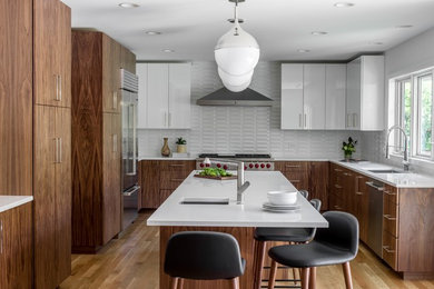 Huge 1950s u-shaped light wood floor kitchen photo in Chicago with an undermount sink, flat-panel cabinets, quartz countertops, white backsplash, ceramic backsplash, stainless steel appliances, an island and white countertops