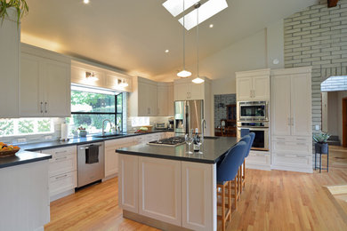 Large transitional u-shaped light wood floor and beige floor open concept kitchen photo in San Luis Obispo with an undermount sink, recessed-panel cabinets, white cabinets, quartz countertops, white backsplash, glass tile backsplash, stainless steel appliances, an island and gray countertops
