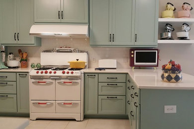 マイアミにある中くらいなミッドセンチュリースタイルのおしゃれなキッチン (シェーカースタイル扉のキャビネット、青いキャビネット、珪岩カウンター、白いキッチンパネル、サブウェイタイルのキッチンパネル、白い調理設備、セラミックタイルの床、ベージュの床) の写真