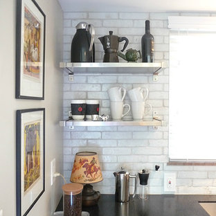 Design ideas for a mid-sized contemporary galley separate kitchen in Columbus with a single-bowl sink, flat-panel cabinets, medium wood cabinets, solid surface benchtops, white splashback, terra-cotta splashback, stainless steel appliances and linoleum floors.
